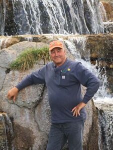 Steven James in front of a Land Escapes Designed Waterfall 